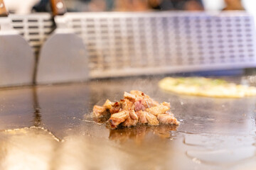 The chef is stirring the delicious Teppanyaki chicken and the aroma is overwhelming