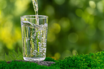 Poster - water pouring into glass on rock with moss