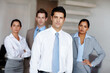 © Leffy/peopleimages.com - Man, corporate and portrait or serious in office, business and company pride with employees in workplace. Professional, people and teamwork collaboration in agency, career and confident coworkers