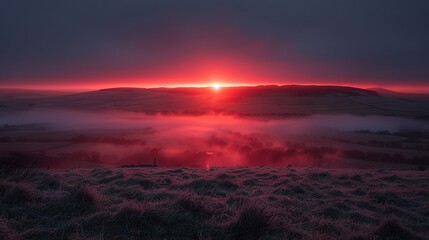 Wall Mural -   The sun sets on a foggy landscape with distant hills and a foggy field in the foreground