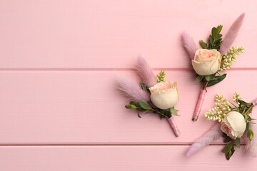 Poster - Many small stylish boutonnieres on pink wooden table, flat lay. Space for text