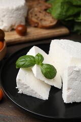 Wall Mural - Fresh ricotta (cream cheese) and basil on table, closeup