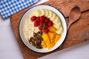 Canvas Print - Delicious and healthy bowl of orange, chocolate, raspberries, and banana oats.