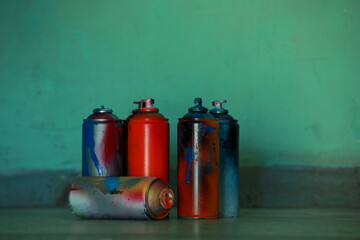 Sticker - Many spray paint cans near green wall