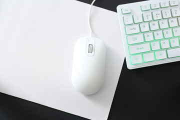 Computer mouse, mousepad and RGB keyboard on black background, top view