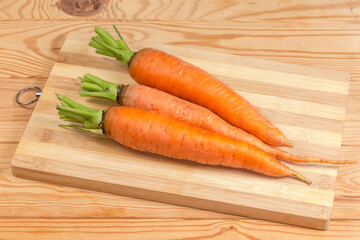 Wall Mural - Washed fresh carrots on cutting board on rustic table