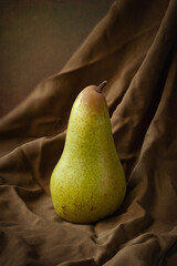 Wall Mural - Ripe pears. Green pear on cloth Still life with one pear on a dark background