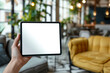 © patchiya - A tablet held in woman’s hand, with the screen facing the viewer and displaying a blank white screen