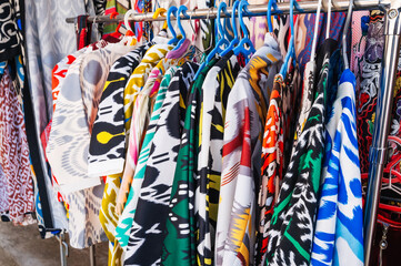 Poster - traditional Asian Uzbek dresses with a bright colorful pattern in oriental street market of Uzbekistan in Tashkent