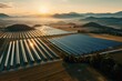 © Milos - A vast solar farm spreads across a picturesque valley as the sun sets, representing the harmony between technology and nature in the pursuit of sustainable energy solutions.