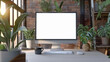 © Mikhail - A blank computer screen for mock up sits on a desk with plants, a coffee mug in a modern home office setting