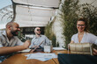 © qunica.com - Young business entrepreneurs strategizing and collaborating on a project. Teamwork for improvement and growth in an outdoor setting.