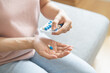 © KMPZZZ - Sick, ill asian young woman, girl hand holding and taking tablet pill capsule, painkiller medicine from stomach pain, head ache, pain for treatment, take drug or vitamin at home, health care concept.