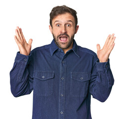 Studio portrait of young Hispanic male celebrating a victory or success, he is surprised and shocked.