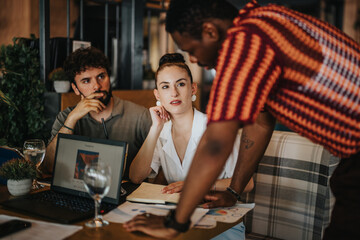 Wall Mural - Diverse people collaborate in a meeting at a coffee bar. Team members discuss a project, showing engagement and teamwork.