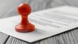© MagicAI - A vibrant red stamp rests on a document, symbolizing approval, authority, and official validation in a professional setting.