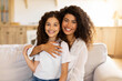 © Home-stock - Family first concept. Portrait of happy mother and daughter hugging and smiling at camera, sitting on sofa at home