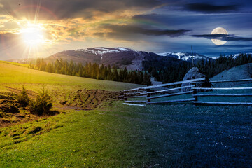 Wall Mural - day and night collage landscape. fence near the meadow path on the hillside. village near forest in mountains with sun and full moon