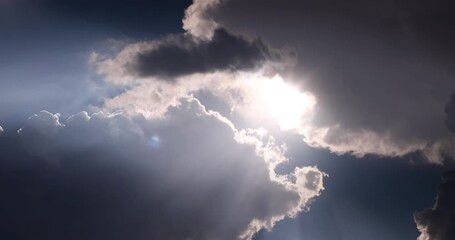 Wall Mural - contrasting sky with clouds and sun rays in motion