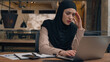 © Yuliia - Displeased sad worker muslim islamic businesswoman in hijab upset online project mistake Arabian man businessman boss coach come help trainee solve problem excited happy woman working laptop in office