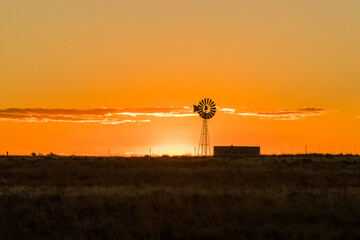 Windmill on a farm during sunset