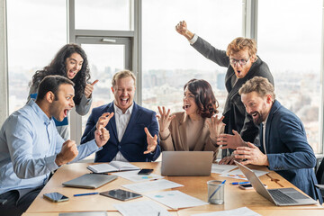 Aufkleber - A group of diverse business professionals gather around a conference table in a modern office, celebrating a shared success. They are all smiling and laughing, with their hands raised in the air
