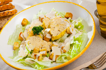 Wall Mural - Traditional Caesar salad with green lettuce, crispy croutons, Parmesan cheese and grilled chicken