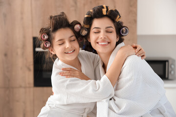 Sticker - Little girl and her mother with hair curlers hugging in kitchen