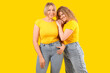 © Pixel-Shot - Beautiful happy women in stylish jeans on yellow background