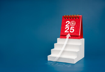 Wall Mural - Happy new year 2025 background. 2025 numbers with target icon on red small desk calendar standing on white stairway with rise arrow on blue background. Business growth, goal and success concept.