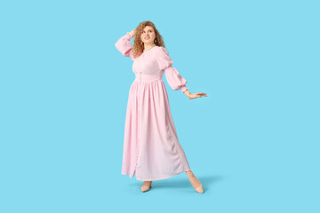 Sticker - Beautiful young woman in stylish pink dress on blue background