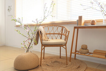 Wall Mural - Beautiful living room with armchair and vases with blooming branches