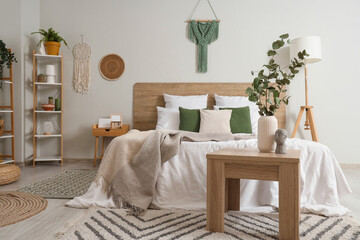 Poster - Interior of light bedroom with bed, shelf unit and eucalyptus in vase