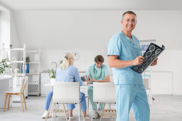 Canvas Print - Male doctor with MRI scan in clinic