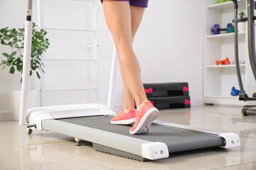 Poster - Sporty young woman training on treadmill in gym