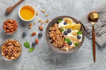 Wall Mural - Homemade crispy granola, yogurt, fruits and berries in bowl on table. Healthy breakfast. Top view