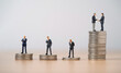 © Dilok - Two businessmen miniature figure hand shaking among businessmen individual standing   on coins stacking for business corporate can make more benefit and profit concept.