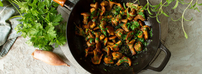 Wall Mural - frying pan with fried chanterelles on a light table