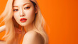 © ALA - Portrait of a beautiful, sexy, smiling, happy blonde Asian woman with perfect skin, orange background, banner.