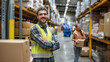 © MikeLegend - Smiling warehouse worker with arms crossed in large distribution center