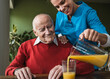 © Westend61 - Happy nurse pouring juice in glass for senior man at table