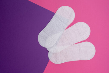 Wall Mural - Women's pads and tampon. Sanitary pads lie next to a tampon on an isolated background on a pink and white background. The concept of health, feminine hygiene and the menstrual cycle 