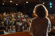 © AlfredoGiordano - horizontal image of a lady doing a speech at a business conference in front of an attentive audience, view from behind