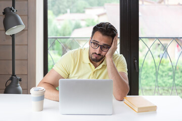 Tired and bored man preparing for exams at university. Stressful education concept	