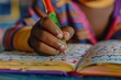 © Igor - Close-up of a child's hand tracing letters in a workbook