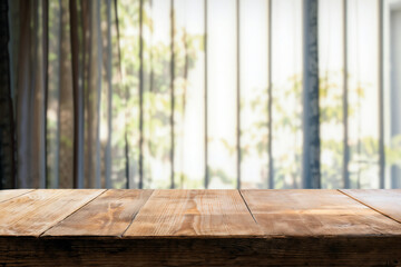 Poster - Empty wooden table top presenting blurred green view from window, perfect for product placement
