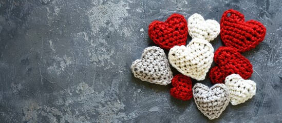 Aufkleber - Greeting card featuring red and white crocheted hearts forming a heart shape on a gray background with copy space image