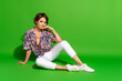 © deagreez - Full length photo of positive charming lady dressed print shirt sitting floor empty space isolated green color background