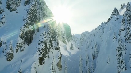 Canvas Print - The sunlight reflects off the glistening snow coating the cliffs creating a magical and serene atmosphere.