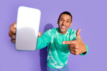 Sticker - Photo of funky cool guy dressed turquoise sweatshirt pointing finger modern device emtpy space isolated violet color background